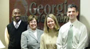 four professional adults standing side by side