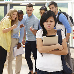 A high school student being bullied by her classmates in the background