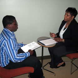 young man being interviewed by woman at small table