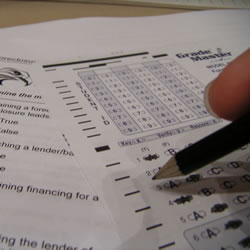 person completing a scantron test with a pencil